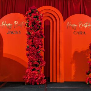 red arches backdrop with rose garlands, red pvc balls, gold chrome decals