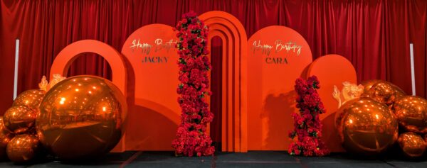 red arches backdrop with rose garlands, red pvc balls, gold chrome decals